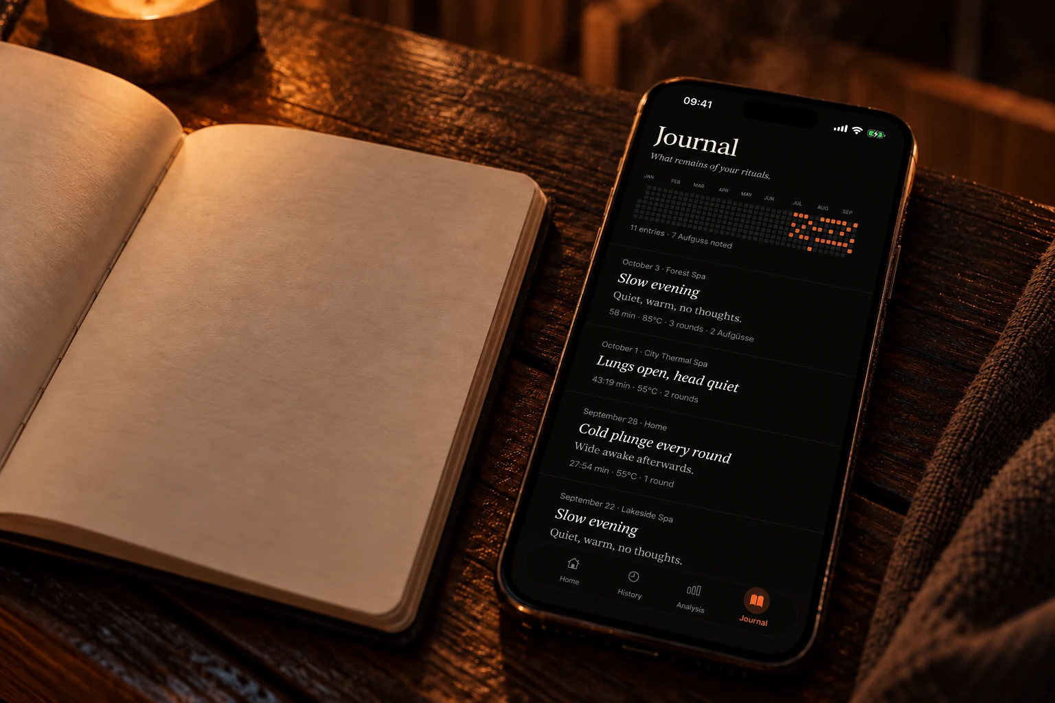 Open notebook next to an iPhone showing the Schwitz journal by candlelight